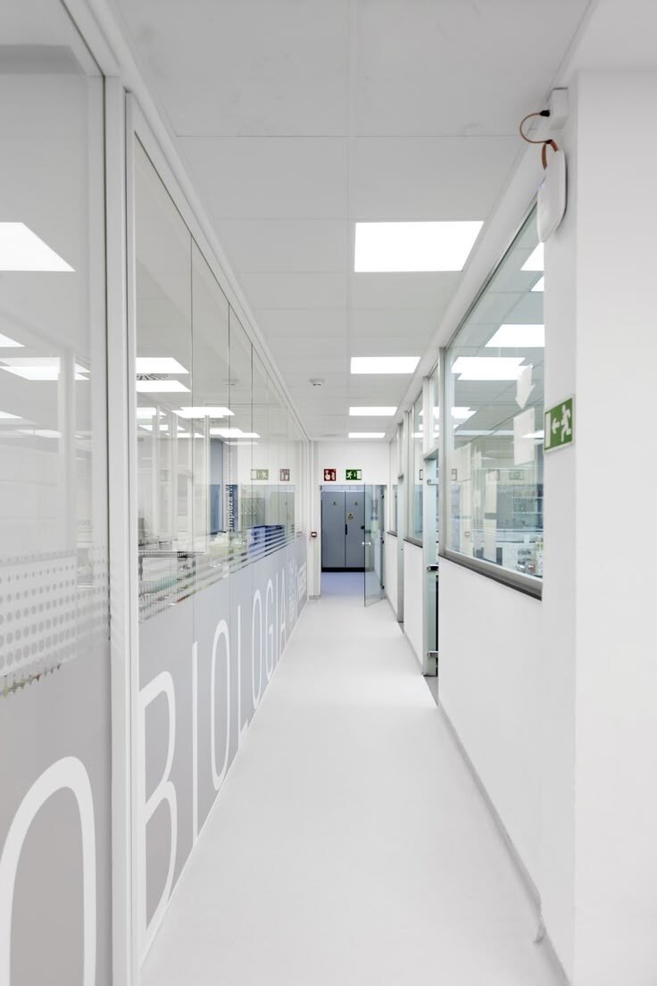 Bright corridor beside glass-walled laboratory spaces
